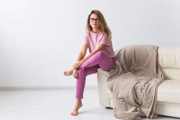 Fiatal vonzó nő gyönyörű színes pizsamában modellnek adja ki magát a nappalijában. Kényelmes hálóing, otthoni relaxáció és női divat koncepció. — Stock Fotó