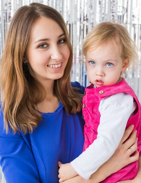 子供の頃、愛と家族の概念-母は光沢のある背景に赤ん坊の娘を保持します。閉鎖 — ストック写真