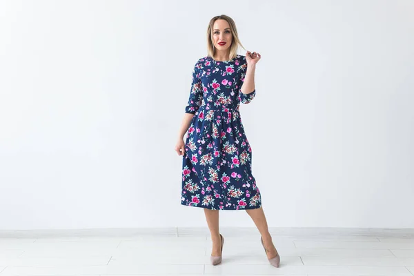 Fashionable young blonde woman in beautiful summer dress posing at white studio with copy space. — Stock Photo, Image