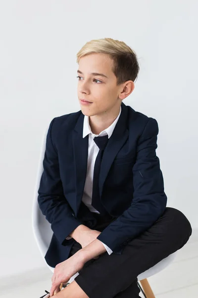 Retrato de adolescente menino de escola elegante em camisa branca e jaqueta contra fundo branco . — Fotografia de Stock