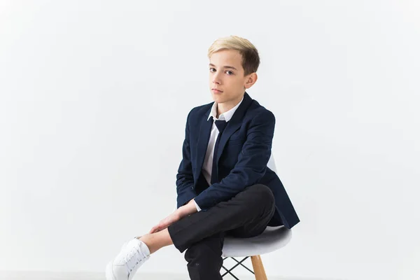 Porträtt av snygg skolpojke tonåring i vit skjorta och jacka mot vit bakgrund. — Stockfoto