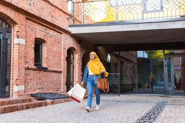 Концепция продажи и покупки - Счастливая арабская девочка с сумками для покупок после шопинга — стоковое фото