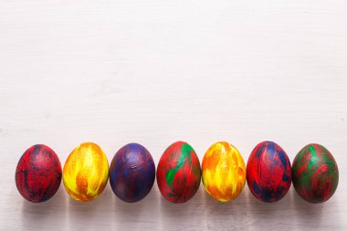 Tatiller, gelenekler ve Paskalya konsepti - Beyaz arka planda çok renkli renkli renkli renkli yumurtalar ve fotokopi alanı. Üst görünüm.