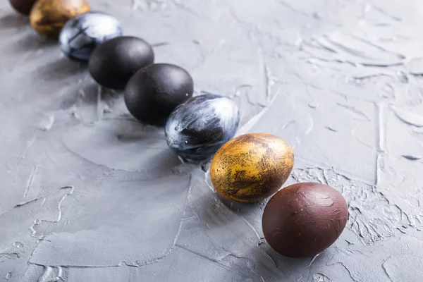 Holidays, traditions and Easter concept - Dark stylish easter eggs on grey background. — Stock Photo, Image