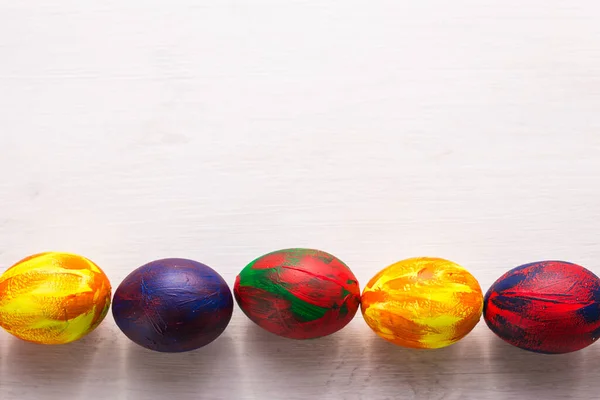 Wakacje, tradycje i koncepcja wielkanocna - wielobarwne dekoracyjne kolorowe jaja na białym tle z przestrzenią do kopiowania. Widok z góry. — Zdjęcie stockowe