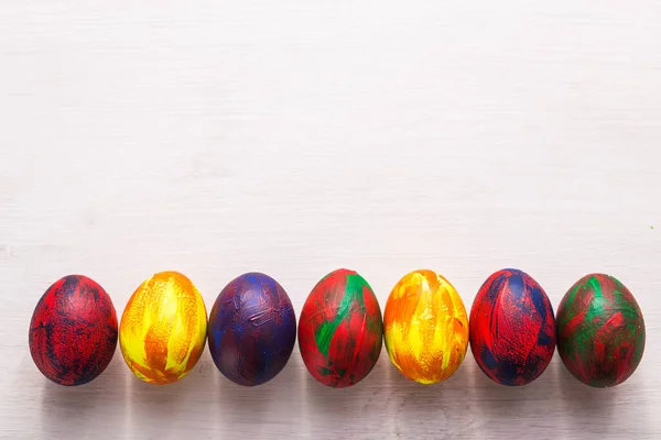 Dovolená, tradice a velikonoční koncept - pestrobarevná dekorativní barevná vejce na bílém pozadí s kopírovacím prostorem. Horní pohled. — Stock fotografie