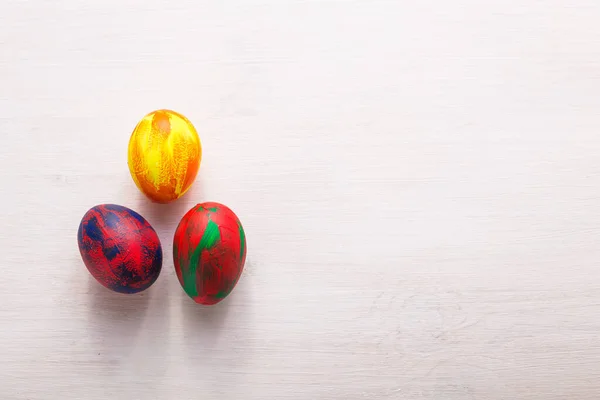 Wakacje, tradycje i koncepcja wielkanocna - wielobarwne dekoracyjne kolorowe jaja na białym tle z przestrzenią do kopiowania. Widok z góry. — Zdjęcie stockowe