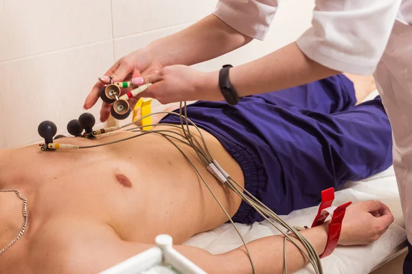 Medicine, health and heart check-up concept - Male patient having ECG electrocardiogram in hospital