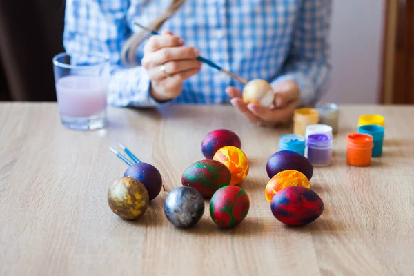 Holidays, handmade and creation concept - Girl draws on Easter egg, close-up. — Stock Photo, Image