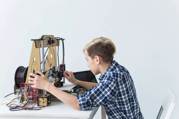 Éducation, enfants, concept de technologie - adolescent garçon imprime sur imprimante 3D . — Photo