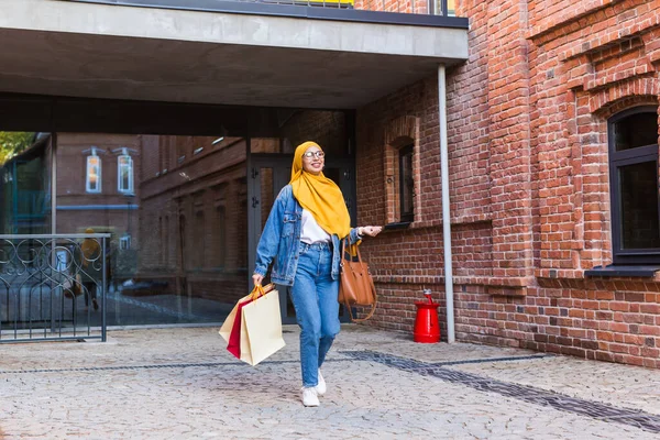 販売と購入のコンセプト-ショッピングバッグと幸せなアラブイスラム教徒の女の子後モール — ストック写真