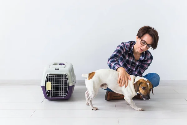 Bolsas de transporte para perros y mascotas concepto de propietario Atractiva hembra alegre en camisa a cuadros tiene mascota favorita. Mujer feliz con su jack russell terrier — Foto de Stock