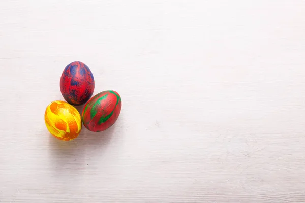 Vacaciones, tradiciones y concepto de Pascua: huevos coloridos decorativos multicolores sobre fondo blanco con espacio para copiar. Vista superior . —  Fotos de Stock