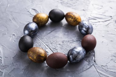 Tatiller, gelenekler ve Paskalya konsepti - Gri arka planda koyu renkli paskalya yumurtaları.