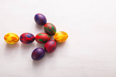 Tatiller, gelenekler ve Paskalya konsepti - Beyaz arka planda çok renkli renkli renkli renkli yumurtalar ve fotokopi alanı. Üst görünüm.