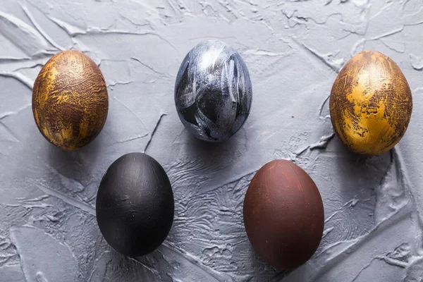 Holidays, traditions and Easter concept - Dark stylish easter eggs on grey background. — Stock Photo, Image