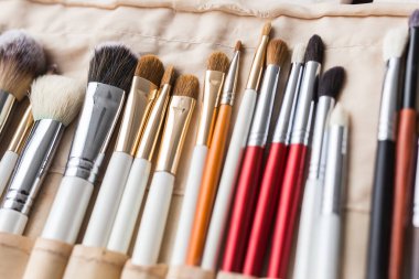 Makyaj, güzellik ve kozmetik konsepti - Makyaj fırçaları hafif bir çantada.