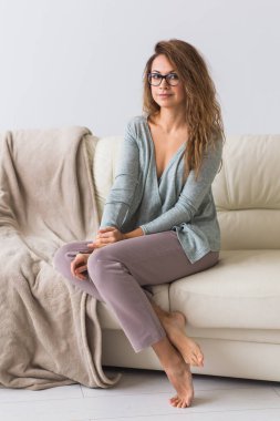 Güzel renkli pijama giymiş, oturma odasında model kılığına girmiş çekici bir kadın. Rahat uyku giysileri, ev rahatlığı ve kadın moda konsepti..
