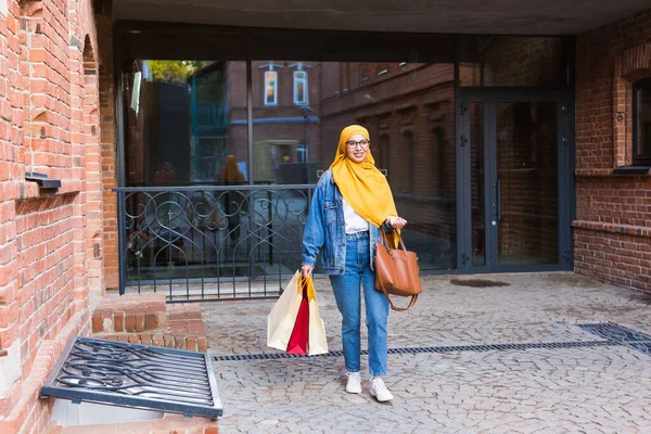 Försäljning och inköp koncept - Happy arab muslim flicka med shoppingväskor efter köpcentret — Stockfoto