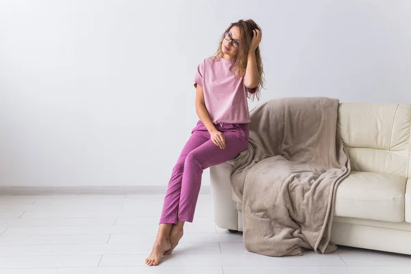 Giovane donna attraente vestita in bellissimo pigiama colorato in posa come modella nel suo soggiorno. Comodo pigiama party, relax domestico e concetto di moda femminile . — Foto Stock