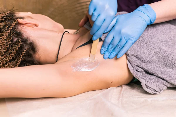 Waxing woman armpit. Salon wax beautician epilation procedure. Waxing female body for hair removal by therapist close up. Smooth underarm concept.