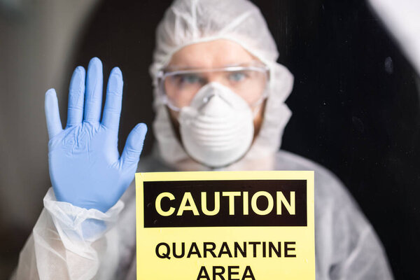 Человек в защитном белом комбинезоне, маске и очках на лице. Коронавирус, пандемия, ковид-19, концепция гриппа и карантина
.