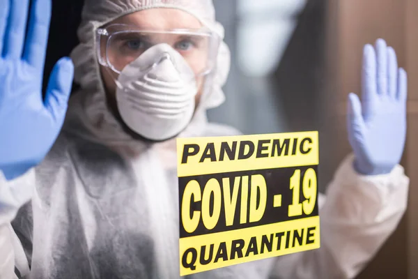Man in beschermende witte overall, masker en bril op zijn gezicht. Coronavirus, pandemie, covid-19, griep en quarantaine. — Stockfoto
