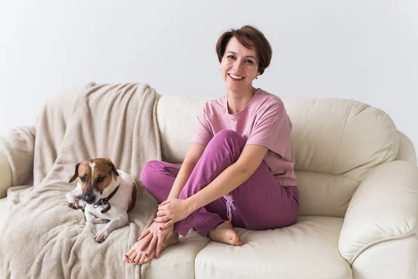 Mladá atraktivní žena oblečená v krásném barevném pyžamu, vydávající se za modelku ve svém obývacím pokoji. Pohodlné spací oděvy, domácí relaxace a ženský módní koncept. — Stock fotografie