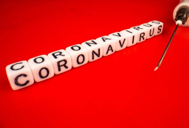 Pandemik ve virüs kavramı - Coronavirus metni ve kırmızı arka planda şırınga. Roman Coronavirus Covid-19.