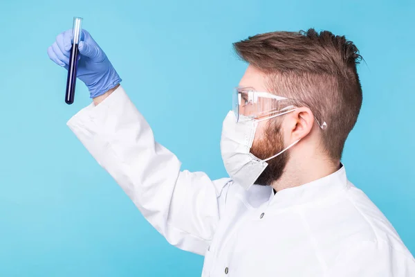 Covid-19, coronavirus, ανάπτυξη εμβολίου, πανδημία, έξαρση και ιατρική αντίληψη - Άνθρωπος επιστήμονας με μάσκα γρίπης και προστατευτικά γάντια που κρατά δοκιμαστικό σωλήνα. — Φωτογραφία Αρχείου