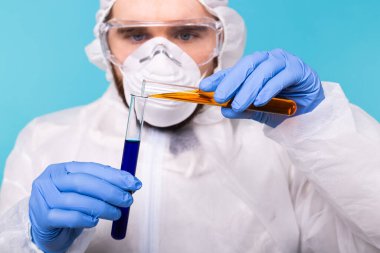 Covid-19, aşı geliştirme, salgın, salgın ve koronavirüs konsepti - bilim adamı kişisel koruyucu ekipman giyip test tüpü tutuyor ve kimyasal deney yapıyor.