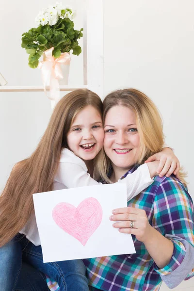 Mothers Day and family holidays - Mother reading greeting card from her daughter.