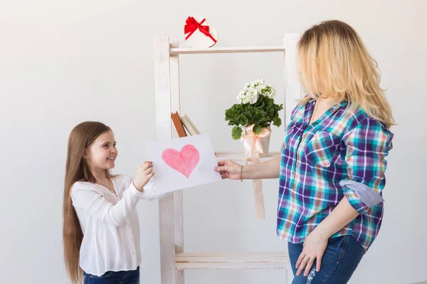 Mothers Day and family holidays - Mother reading greeting card from her daughter.