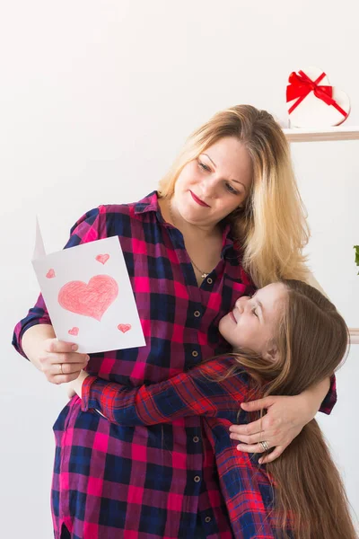 Día de las Madres y fiestas familiares - Madre leyendo la tarjeta de felicitación de su hija . — Foto de Stock