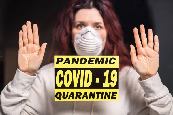 Coronavirus, quarantaine, covid-19 en pandemie concept. Droevige en zieke vrouw van het corona virus die door het raam kijkt. Blijf thuis.. — Stockfoto