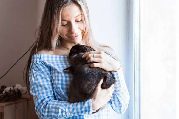 Концепция домашних животных и Пасхи - девочка обнимает дома коричневого кролика . — стоковое фото