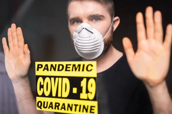 Coronavirus, karantina, covid-19 dan konsep pandemi. Pria sakit dan sedih dengan virus corona melihat melalui jendela. Tinggal di rumah. — Stok Foto