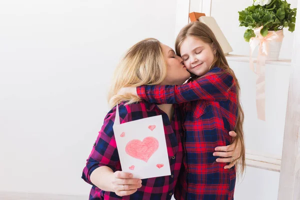 Mothers Day and family holidays - Mother reading greeting card from her daughter.