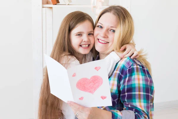 Anneler Günü ve aile tatilleri - Anne kızından tebrik kartı okuyor. — Stok fotoğraf