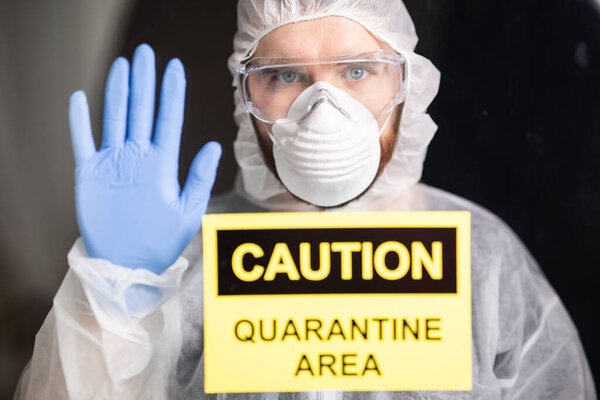 Человек в защитном белом комбинезоне, маске и очках на лице. Коронавирус, пандемия, ковид-19, концепция гриппа и карантина
.