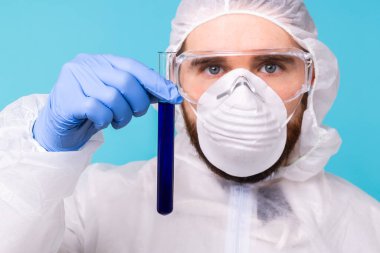 Covid-19, aşı geliştirme, salgın, salgın ve koronavirüs konsepti - bilim adamı kişisel koruyucu ekipman giyip test tüpü tutuyor ve kimyasal deney yapıyor.