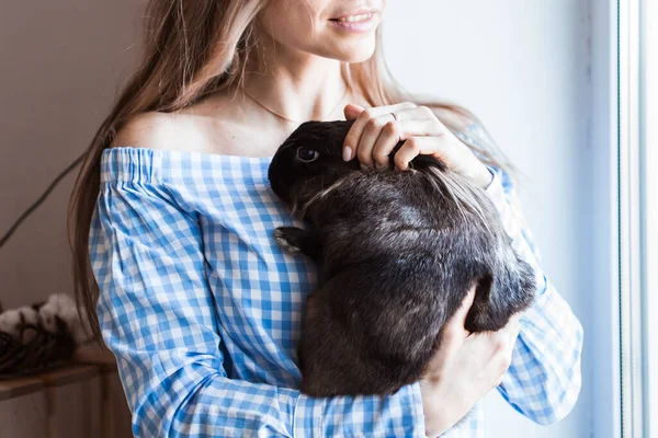 Haustier und Osterkonzept - Glückliches Mädchen umarmt braunes Kaninchen zu Hause. — Stockfoto