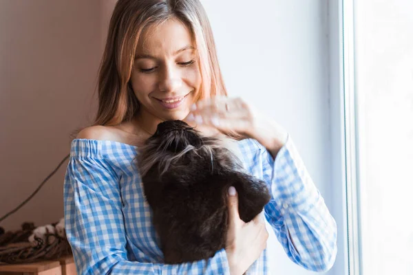 Pet och påsk koncept - Glad flicka kramar brun kanin hemma. — Stockfoto