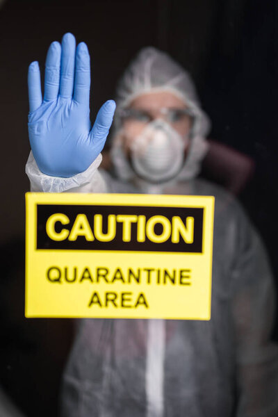 Человек в защитном костюме и в защитной медицинской маске показывает стоп-жест. Эпидемиолог показывает жест нет. Остановить коронавирус или ковид-19 и пандемию. Сиди дома. Карантинная концепция
.