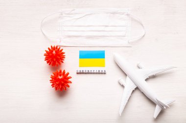 Uçak modeli, yüz maskesi ve Ukrayna bayrağı. Koronavirüs salgını. Avrupa ve Asya 'dan gelen turistler ve Coronavirus covid-19 yolcuları için uçuş yasağı ve kapalı sınırlar.