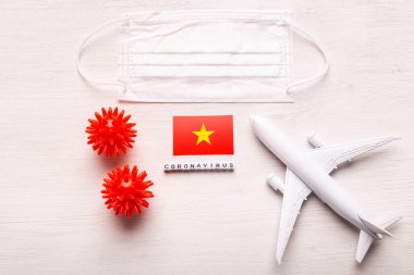 Uçak modeli, yüz maskesi ve Vietnam bayrağı. Koronavirüs salgını. Avrupa ve Asya 'dan gelen turistler ve Coronavirus covid-19 yolcuları için uçuş yasağı ve kapalı sınırlar.
