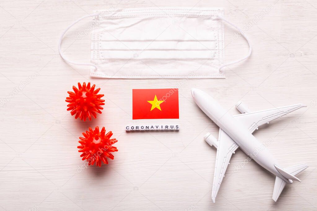 Plane model and face mask and flag Vietnam. Coronavirus pandemic. Flight ban and closed borders for tourists and travelers with coronavirus covid-19 from Europe and Asia.