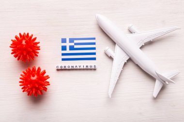Uçak modeli ve Yunanistan bayrağı. Koronavirüs salgını. Avrupa ve Asya 'dan gelen turistler ve Coronavirus covid-19 yolcuları için uçuş yasağı ve kapalı sınırlar.
