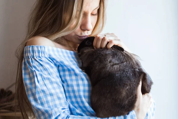 Mascotas y concepto de Pascua - Chica feliz abrazando conejo marrón en casa . — Foto de Stock