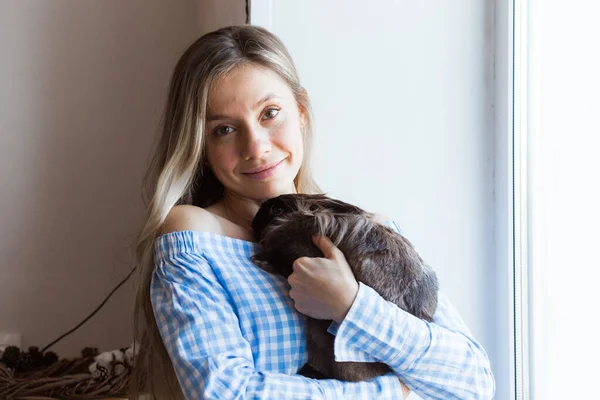 Mascotas y concepto de Pascua - Chica feliz abrazando conejo marrón en casa . — Foto de Stock